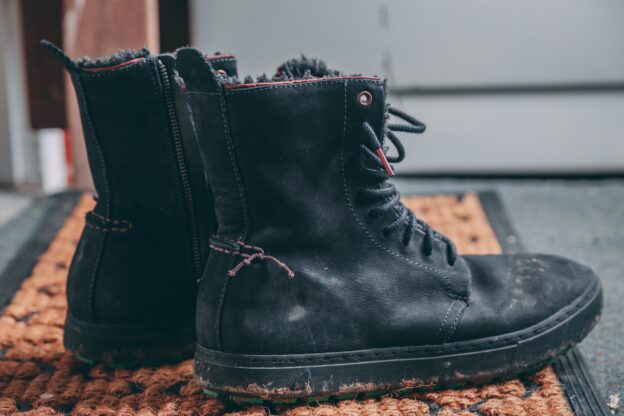 pair of black lace up boots on area rug